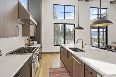 a kitchen with white counter tops and windows at Cloud N9NE Chalet in Fraser