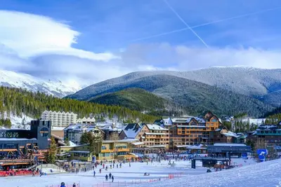 a ski resort with people in the snow and mountains at Timber Fox 1208 apts in Winter Park