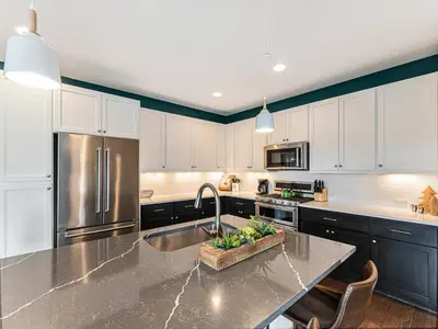 a kitchen with white cabinets and a stainless steel refrigerator at Rendezvous - 99 Stagecoach in Fraser