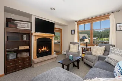 a living room with a fireplace and a tv at Value Unit 1422 - 2BR - Zephyr Mountain Lodge condo in Winter Park