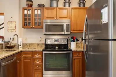 a kitchen with wooden cabinets and a stainless steel refrigerator at Value Unit 1422 - 2BR - Zephyr Mountain Lodge condo in Winter Park