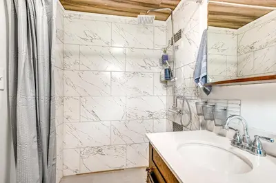 a white bathroom with a sink and a shower at Aurora Abode 7 Mi to Dtwn Denver! in Aurora