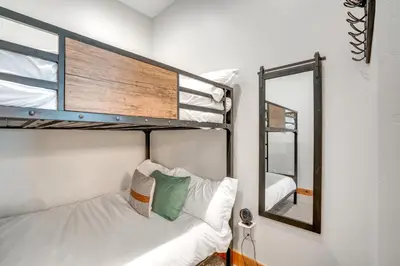 a bedroom with two bunk beds and a mirror at Modern Elk Creek Condo with Hot Tub and Heated Floors in Fraser