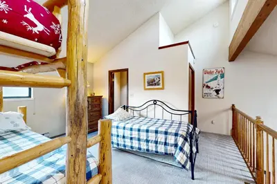 a bedroom with two bunk beds and a staircase at Viking Alpine Haven in Winter Park
