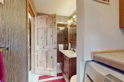 a bathroom with a white door and a sink and a counter at Viking Alpine Haven in Winter Park
