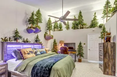 a bedroom with a bed and christmas trees on the wall at Immersive Spa Retreat with Sauna & 15m to Red Rocks in Lakewood