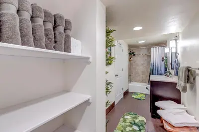 a bathroom with white walls and white shelves at Immersive Spa Retreat with Sauna & 15m to Red Rocks in Lakewood