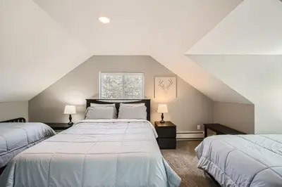 a attic bedroom with two beds and two lamps at Golden Gate Getaway home in Black Hawk