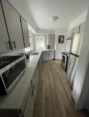 a kitchen with white cabinets and a stainless steel refrigerator at Executive Ranch near Old Town in Fort Collins