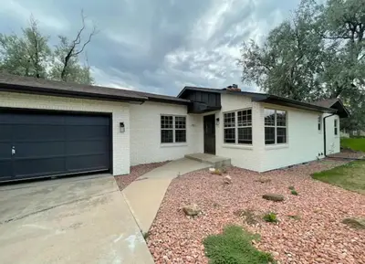 a white house with a garage at Executive Ranch near Old Town in Fort Collins