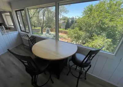 a table and chairs in a room with a large window at Executive Ranch near Old Town in Fort Collins
