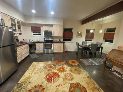 a kitchen with a refrigerator and a table with chairs at River Mountain Getaway-private, large, in- law apt in Jamestown