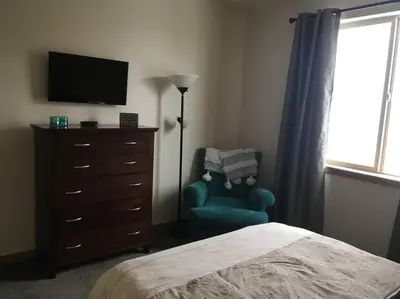 a bedroom with a bed and a dresser and a chair at Large Winter Park Condo overlooking Hideaway Park! in Hideaway Park