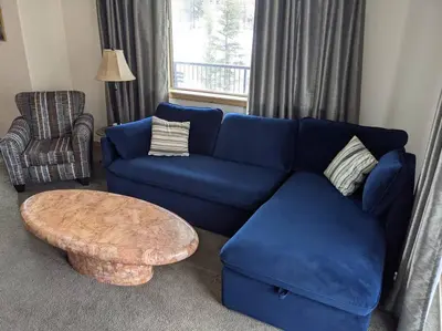 a blue couch and a coffee table in a living room at Large Winter Park Condo overlooking Hideaway Park! in Hideaway Park