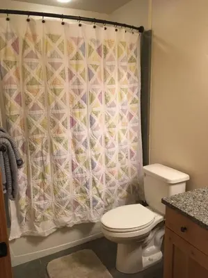 a bathroom with a toilet and a shower curtain at Large Winter Park Condo overlooking Hideaway Park! in Hideaway Park