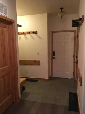 a hallway with a white door and a wooden floor at Large Winter Park Condo overlooking Hideaway Park! in Hideaway Park