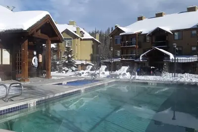 a swimming pool covered in snow next to a building at Large Winter Park Condo overlooking Hideaway Park! in Hideaway Park