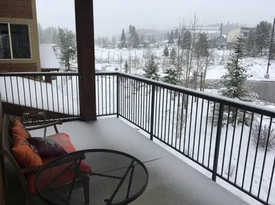 a balcony with a view of a snow covered yard at Large Winter Park Condo overlooking Hideaway Park! in Hideaway Park