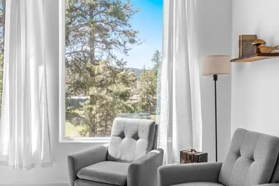 a living room with two chairs and a large window at Near Red Rocks with Hot Tub, Fire Pit and Views in Indian Hills