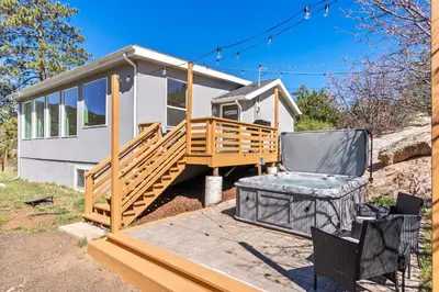a mobile home with a deck and a chair at Near Red Rocks with Hot Tub, Fire Pit and Views in Indian Hills