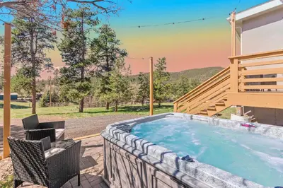 a hot tub on a patio with a table and chairs at Near Red Rocks with Hot Tub, Fire Pit and Views in Indian Hills