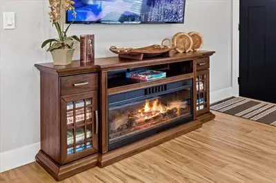 a wooden entertainment center with a fireplace in a living room at Whole House Relaxing Oasis by Fitzsimmons Campus in Aurora