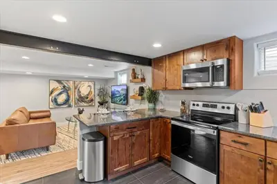 a kitchen with wooden cabinets and a stove top oven at Whole House Relaxing Oasis by Fitzsimmons Campus in Aurora