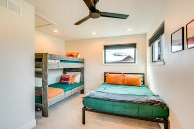 a bedroom with two bunk beds and a ceiling fan at Private Hot Tub and Patio Granby Mtn Retreat! in Granby
