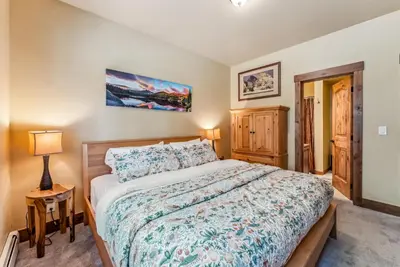 a bedroom with a large bed and a lamp at Mountain Escape with Hot Tub Near Ski Resorts and I 70 in Silverthorne
