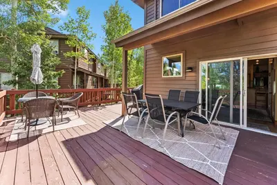 a patio with a table and chairs on a deck at Mountain Escape with Hot Tub Near Ski Resorts and I 70 in Silverthorne