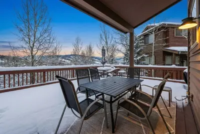 a table and chairs on a deck in the snow at Mountain Escape with Hot Tub Near Ski Resorts and I 70 in Silverthorne