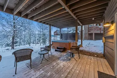 a screened porch with chairs and a grill in the snow at Mountain Escape with Hot Tub Near Ski Resorts and I 70 in Silverthorne