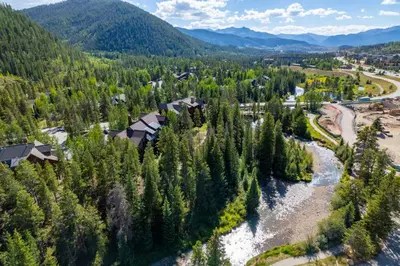 an aerial view of a river and forest at 1824 The Seasons townhouse in Keystone