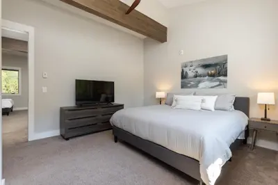 a bedroom with a large bed and a flat screen tv at 1824 The Seasons townhouse in Keystone
