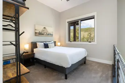a bedroom with a bed and a ladder and a window at 1824 The Seasons townhouse in Keystone