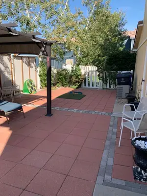 a patio with white chairs and an umbrella at Charming 3 bed 3 bath home, super cozy, close to DIA in Altura