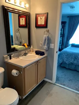 a bathroom with a sink and a mirror and a bed at Charming 3 bed 3 bath home, super cozy, close to DIA in Altura