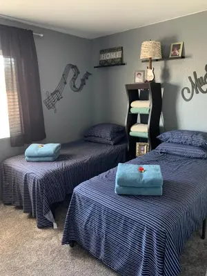 a room with two twin beds with blue sheets at Charming 3 bed 3 bath home, super cozy, close to DIA in Altura