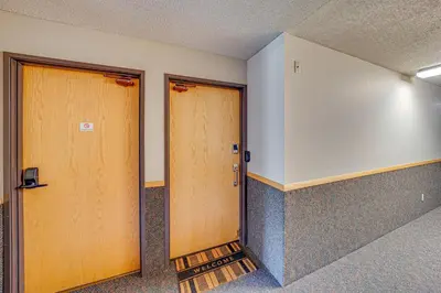 two wooden doors in an empty room at Ski Retreat with Hot Tub Access in Winter Park! in Winter Park