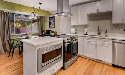 a kitchen with white cabinets and a stove top oven at Mid Summer Night's Dream w Hot Tub Theater Game Room in Arvada