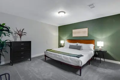 a bedroom with a large bed with a green wall at Mid Summer Night's Dream w Hot Tub Theater Game Room in Arvada