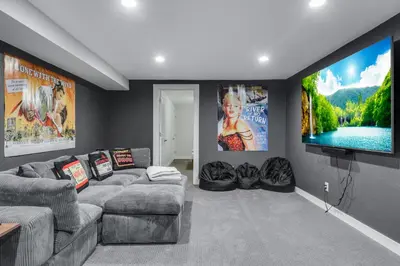 a living room with a large flat screen tv on a wall at Mid Summer Night's Dream w Hot Tub Theater Game Room in Arvada