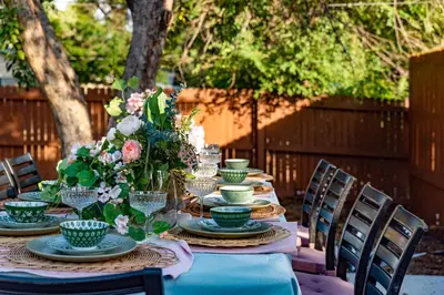 a table with plates and bowls and flowers on it at Mid Summer Night's Dream w Hot Tub Theater Game Room in Arvada