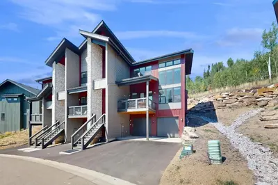 a house with a patio and two chairs in front of it at Rendezvous Retreat in Fraser