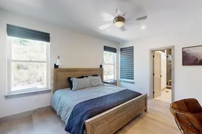 a bedroom with a bed and two windows at Rendezvous Retreat in Fraser