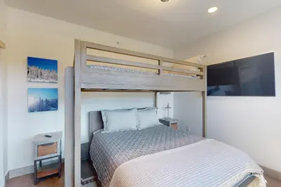a bedroom with a bunk bed and a tv at Rendezvous Retreat in Fraser