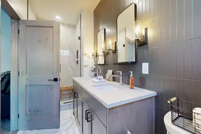 a bathroom with a sink and two mirrors and a shower at Rendezvous Retreat in Fraser