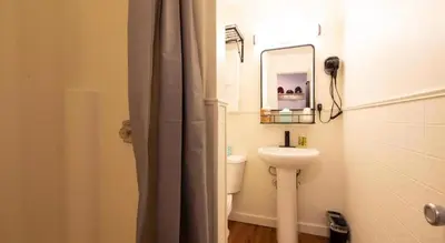 a bathroom with a sink and a mirror and a toilet at LOGE Breckenridge in Gold Hill