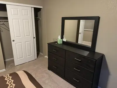 a bedroom with a black dresser and a mirror at Humble Home in Aurora