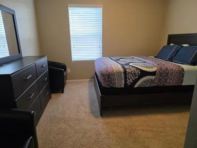 a bedroom with a bed and a dresser and a television at Humble Home in Aurora